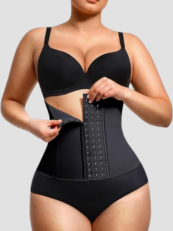 Curvy woman wearing black latex waist trainer corset with hook-eye closure and outer compression layer for tummy control and hourglass shaping.