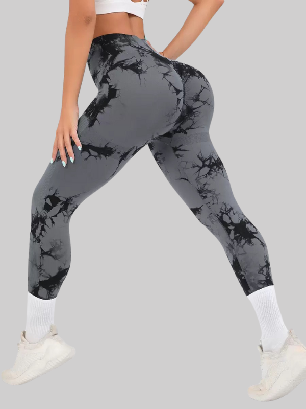Woman wearing high waist cropped tie-dye leggings with seamless fit and scrunch butt design, styled for workouts or casual wear.