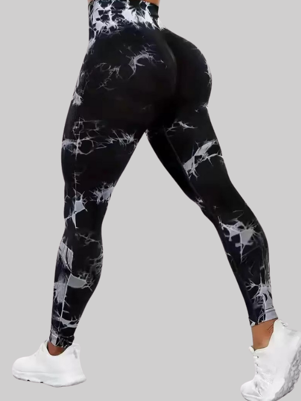 Woman wearing black tie-dye seamless leggings with scrunch butt design, posing in white sneakers for a sporty, flattering look.