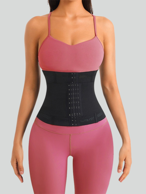 Black high-compression waist trainer with triple hook design worn by woman in pink workout set for tummy control and slimming support