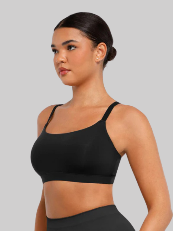 Woman wearing a wireless black square neck bra with adjustable straps, showcasing a sleek and seamless fit for everyday wear and comfort.