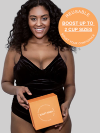 Smiling woman wearing a black outfit holding SculptTouch box with badge showing “Boost up to 2 cup sizes – Reusable sticky inserts.