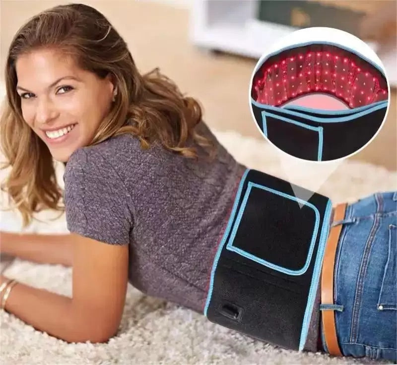 Smiling woman lying on her stomach wearing a red light therapy belt on her lower back, with inset showing activated LED lights inside the belt.